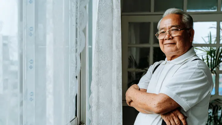 Asian man smiling at camera with arms crossed