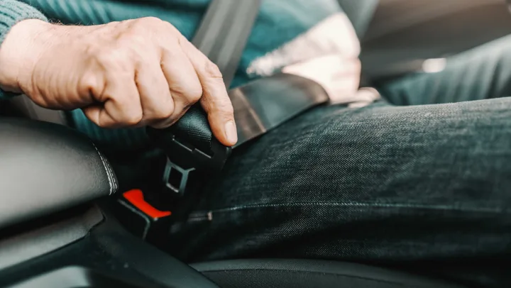 image of senior man putting seatbelt on
